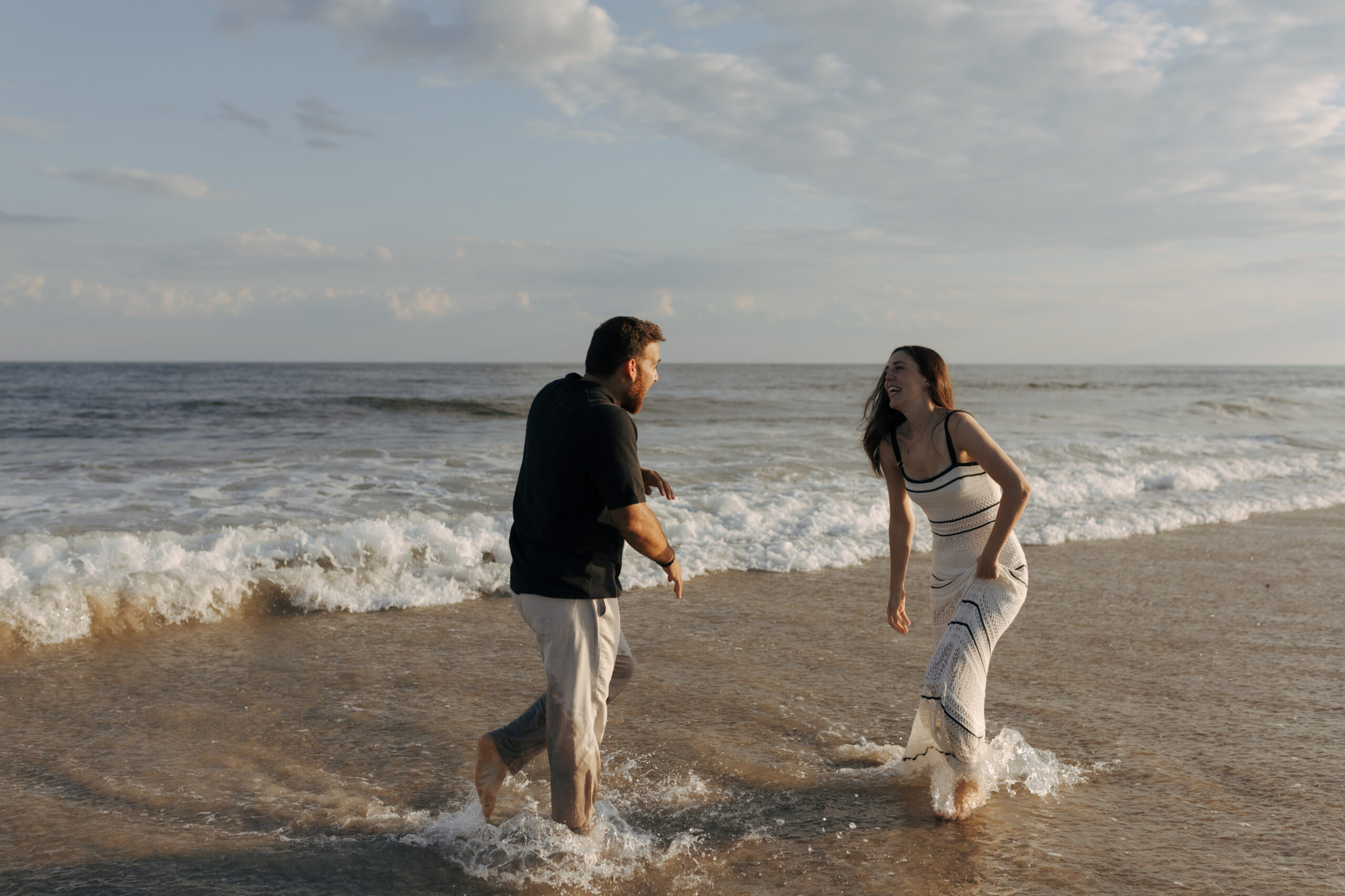 a couple playing in the water at the beach