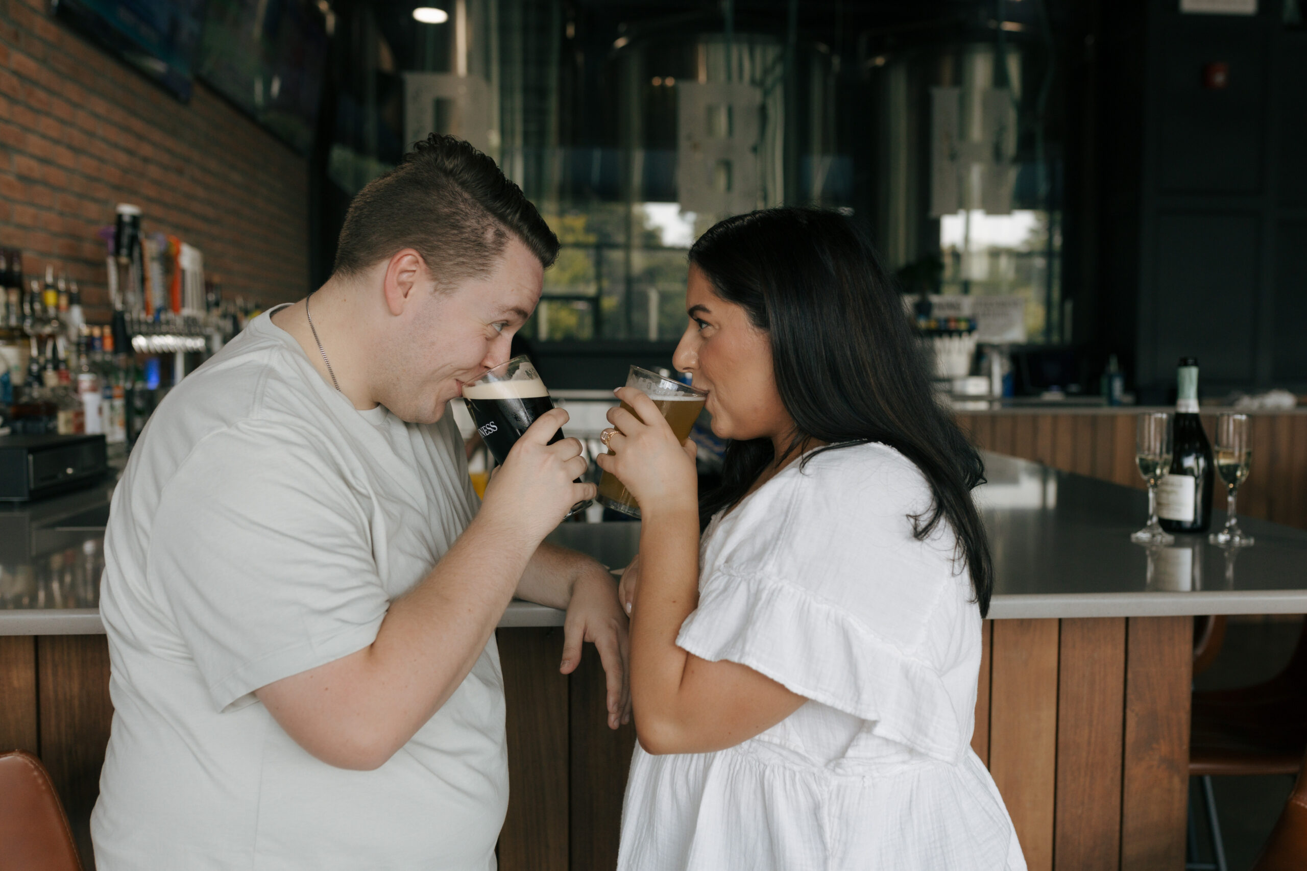 newly engaged couple enjoying a beer together at a brewery